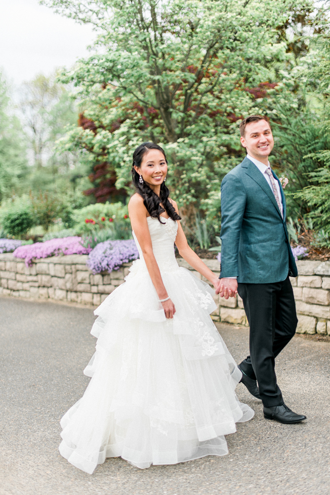 Bride and groom walking hand in hand on their beautiful summer wedding day at the Scotland Run Golf Club by New Jersey wedding photographers, Michelle Behre.