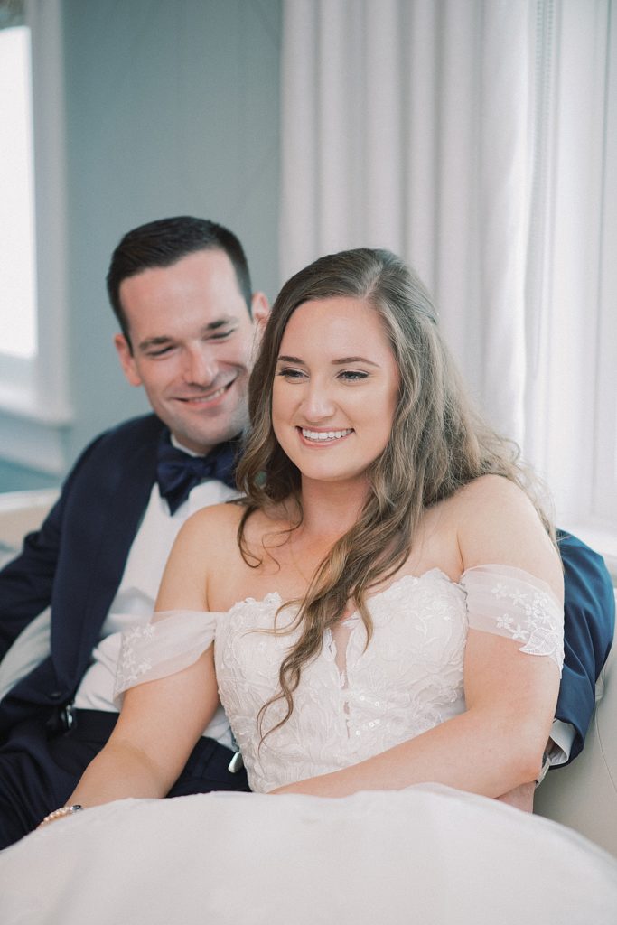 The bride and groom relaxing as husband and wife moments prior to their first dance at the RiverCrest Golf Club adorned in an elegant bridal gown and Christian Louboutin shoes by wedding photographers Michelle Behre Photography.